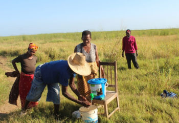 Farmers wash their hands at a field handwashing station.