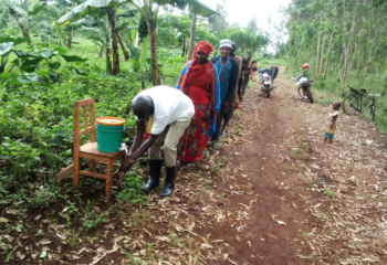 Burundian farmers line up to wash hands at a field day