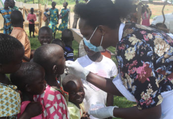 Woman giving vaccines to children