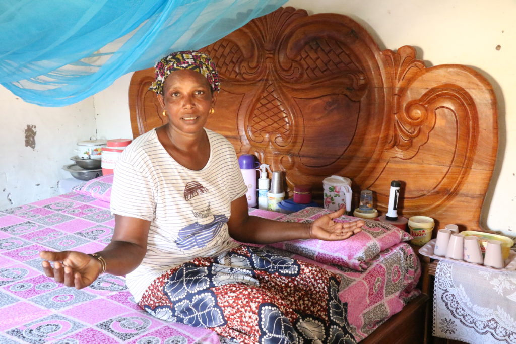 Halimatou sits on her newly-purchased bed