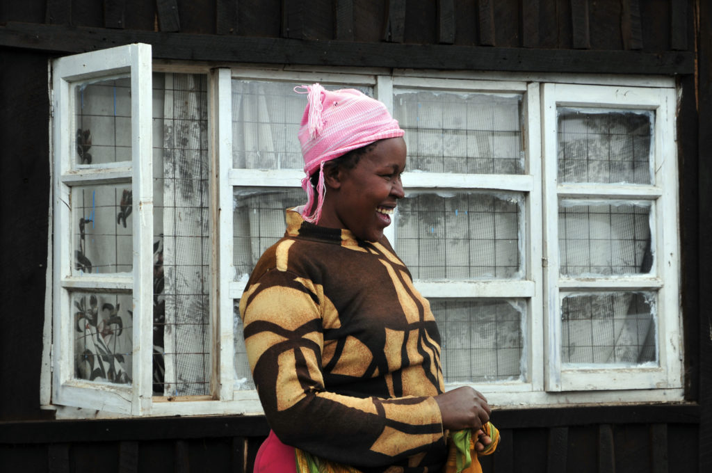 Kenyan smiling and standing in front of a building