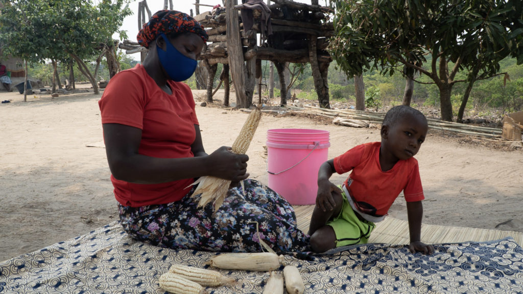 Mrs. Wachi and her son retrieving maize from her granary.