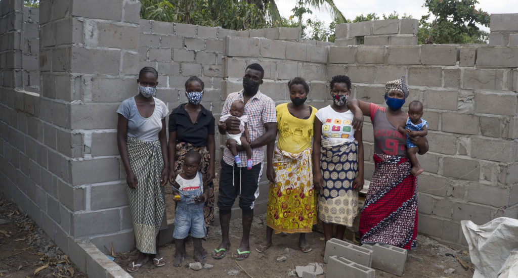 Flora and her family stand in the construction site of their new house. Proceeds earned selling vegetables allowed them to rebuild after Cyclone Idai.