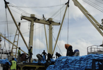 Men working on boat transporting fertilizer