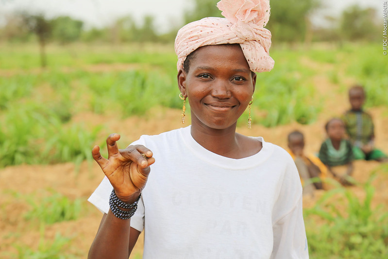 Young woman stands in a field in Mali