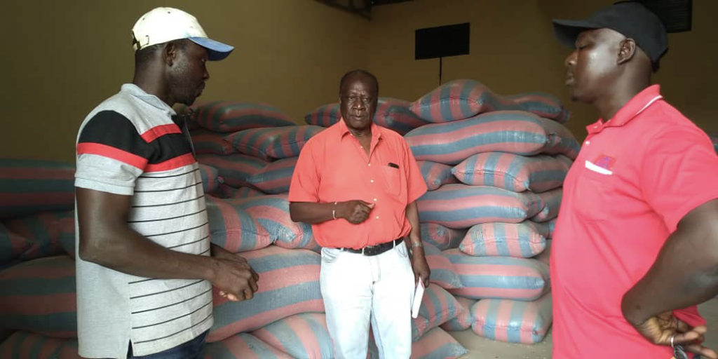 Dr. Bationo (pictured middle) explains microdosing to two workers in a fertilizer warehouse