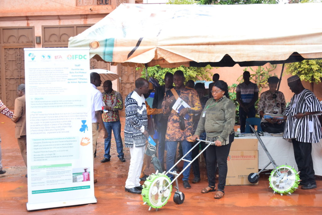 A woman demonstrates a fertilizer technology used by the TAAT project