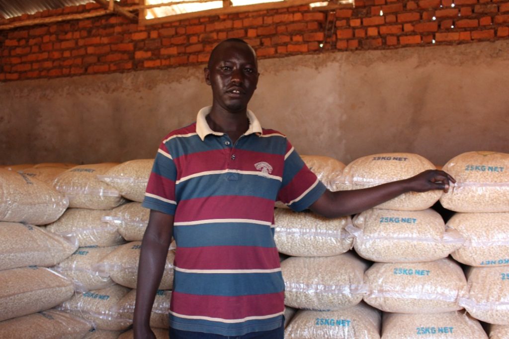 Man stands in front of stored seed bags