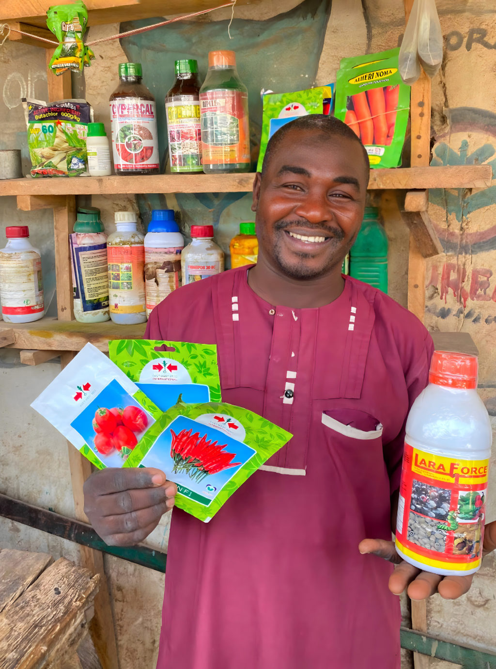 A man holding packages of agricultural inputs