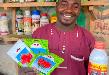 A man holding packages of agricultural inputs