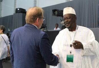 Henk van Duijn (left) meets an leader from Africa in white (right); they are shaking hands