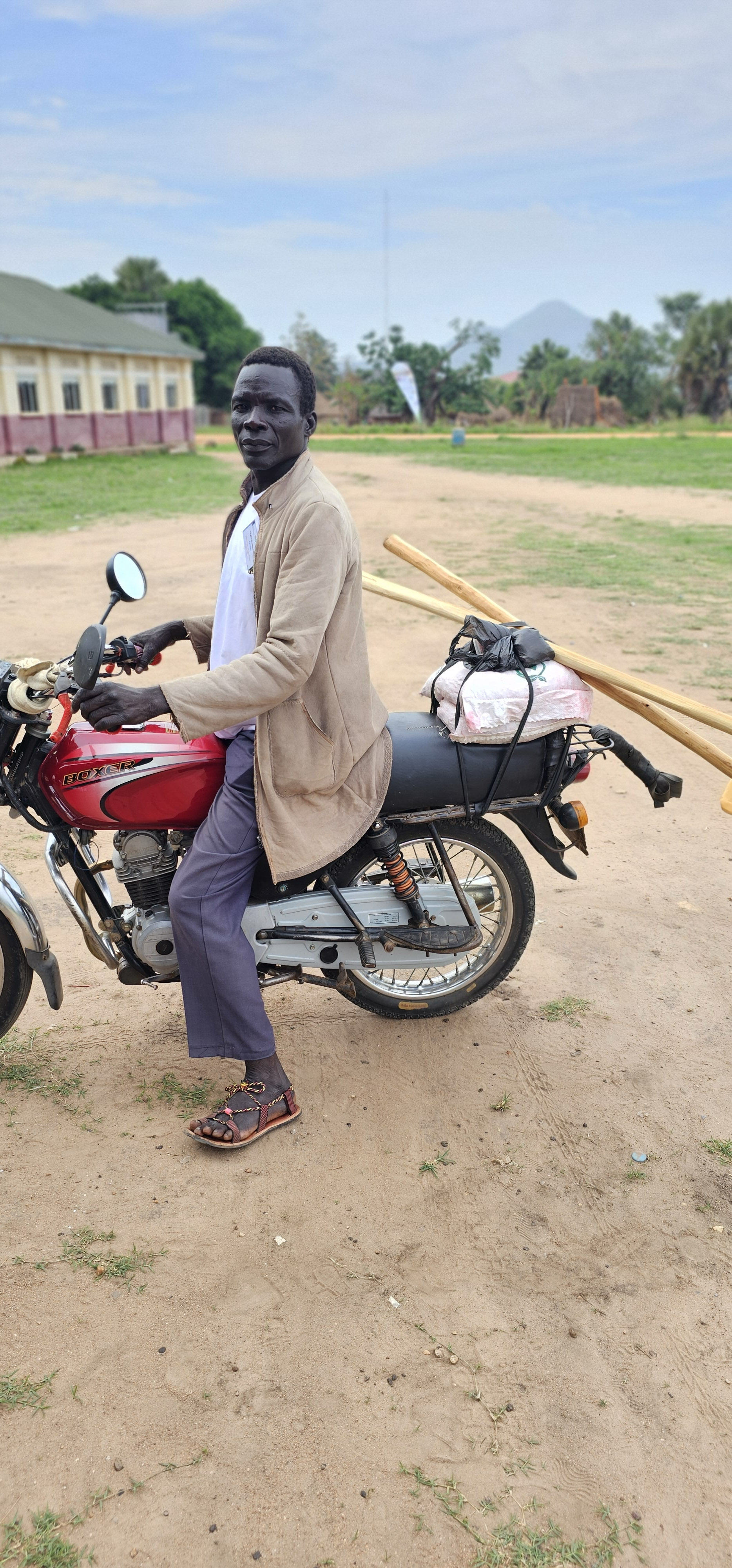 A South Sudanese producer carries seeds on his motorcycle after visiting a local agricultural input shop.