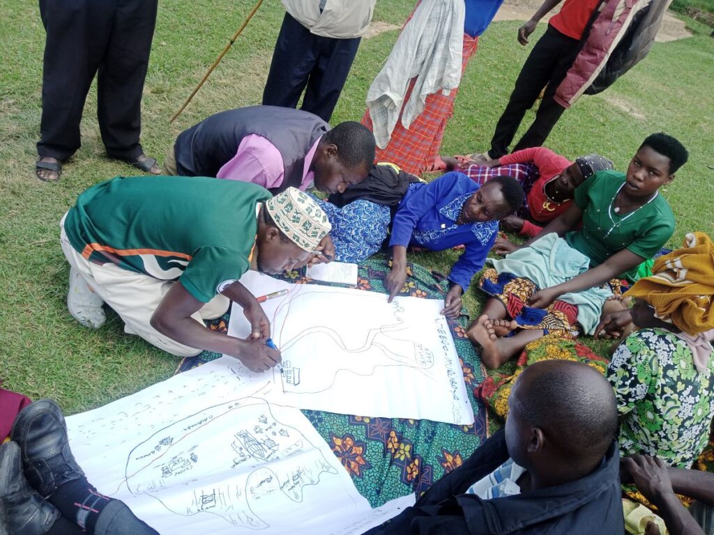 A group of people gathered around outside on the ground and standing as someone draws on a big sheet of paper about their vision.