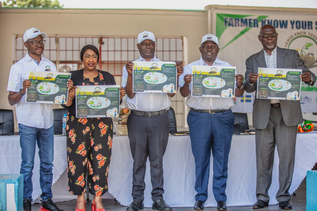 A group of five people posing while holding the Farmer Know Your Soil Pledge.