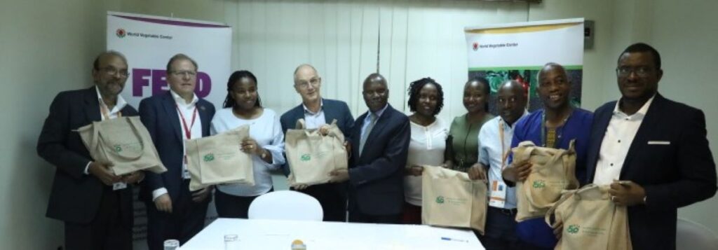 A group of people posing for a picture and holding bags with logos.