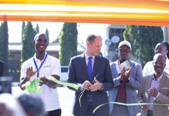 A group of people cutting a ribbon for the event.