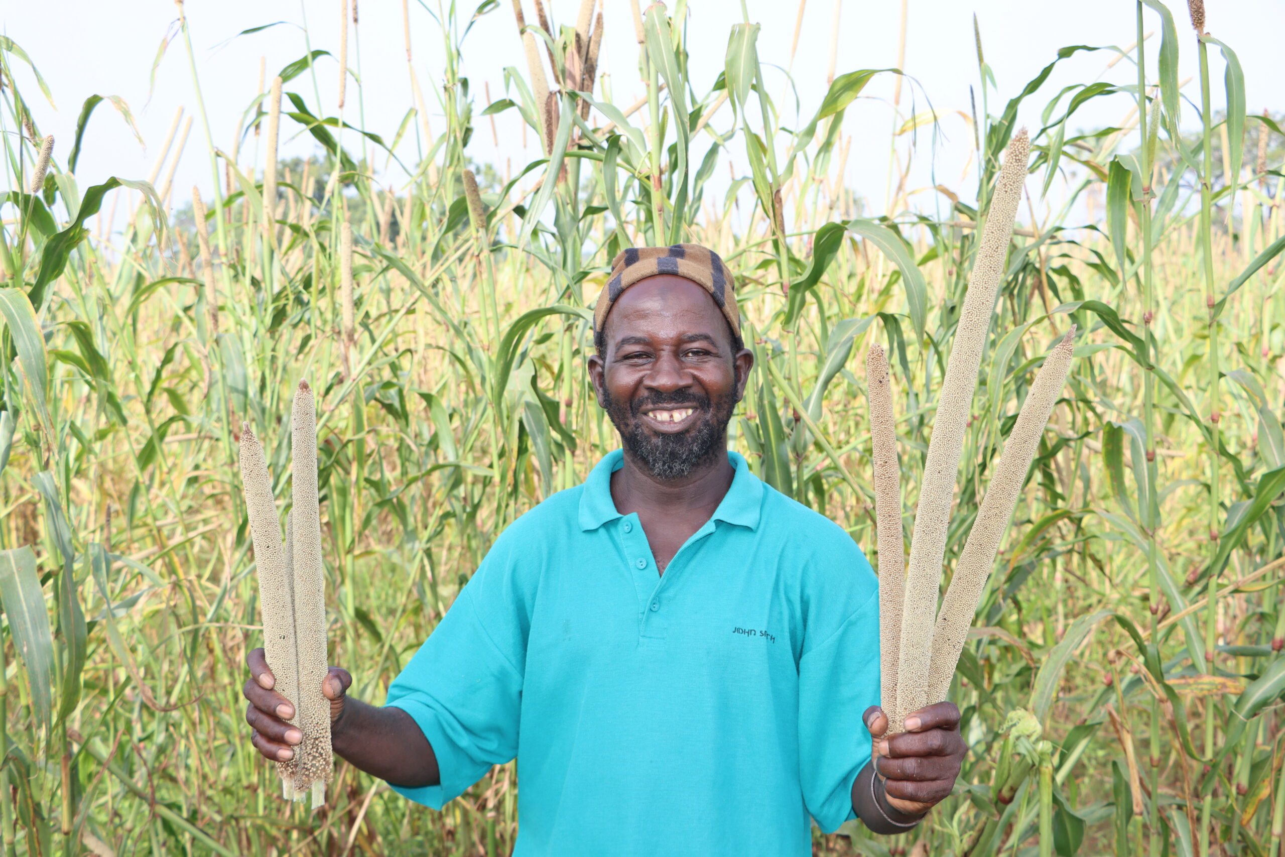 Farmer holding a bundle of millets.