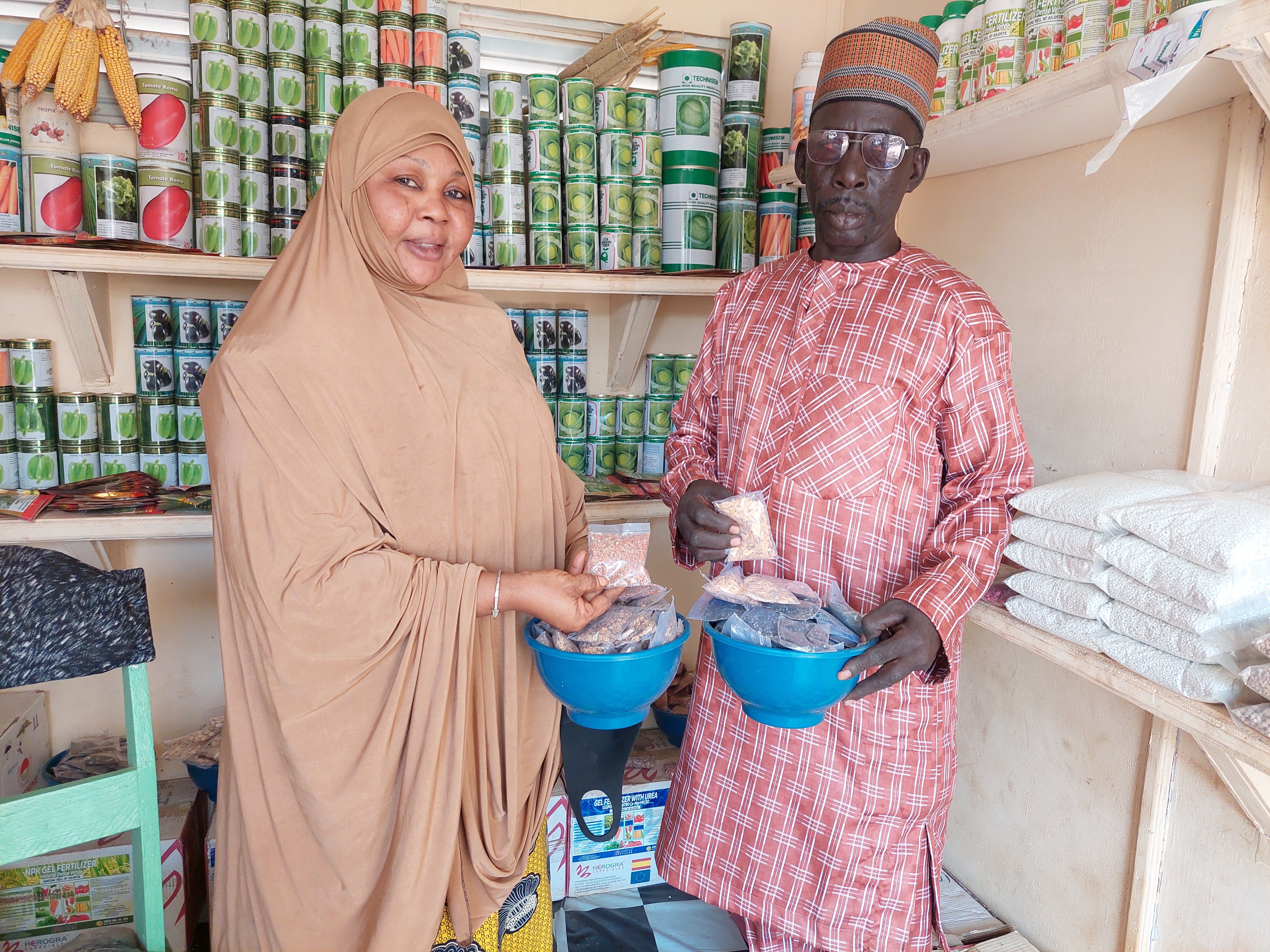 A women and man showcase their seeds and other agricultural input products in in their market. 