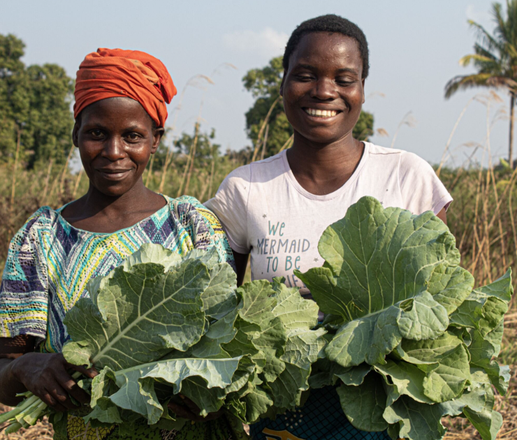 Two women holding cabbage,