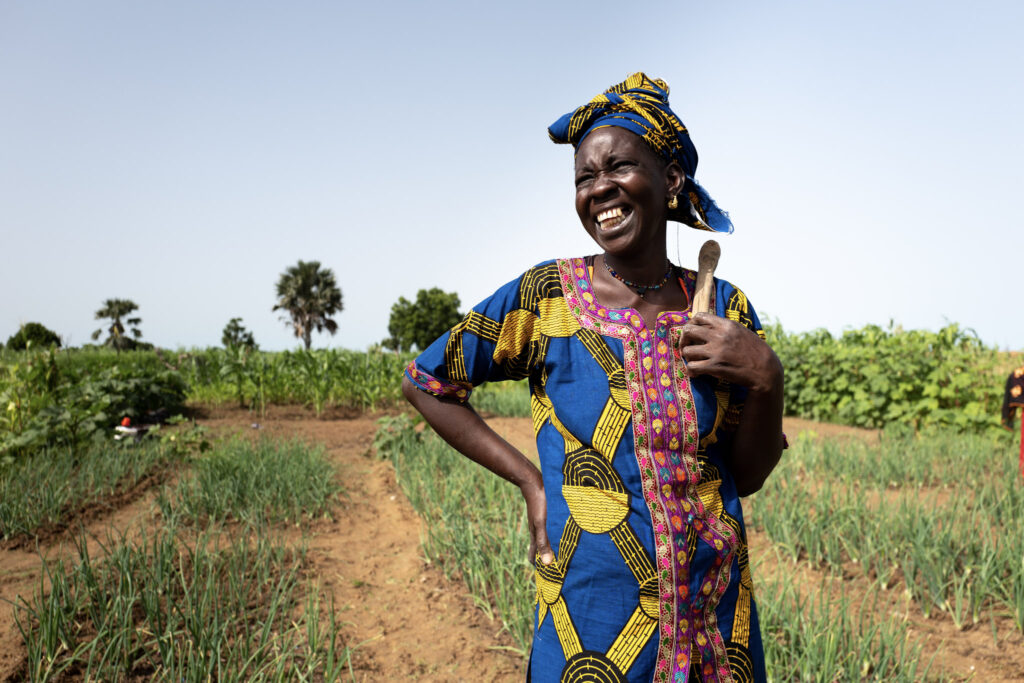 A female farmer smiling in a field.