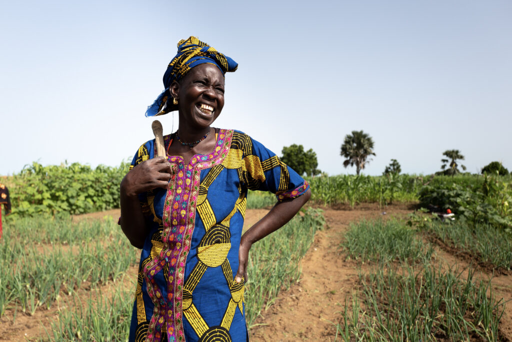 A women smiles in a field.