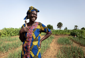 A women smiles in a field.