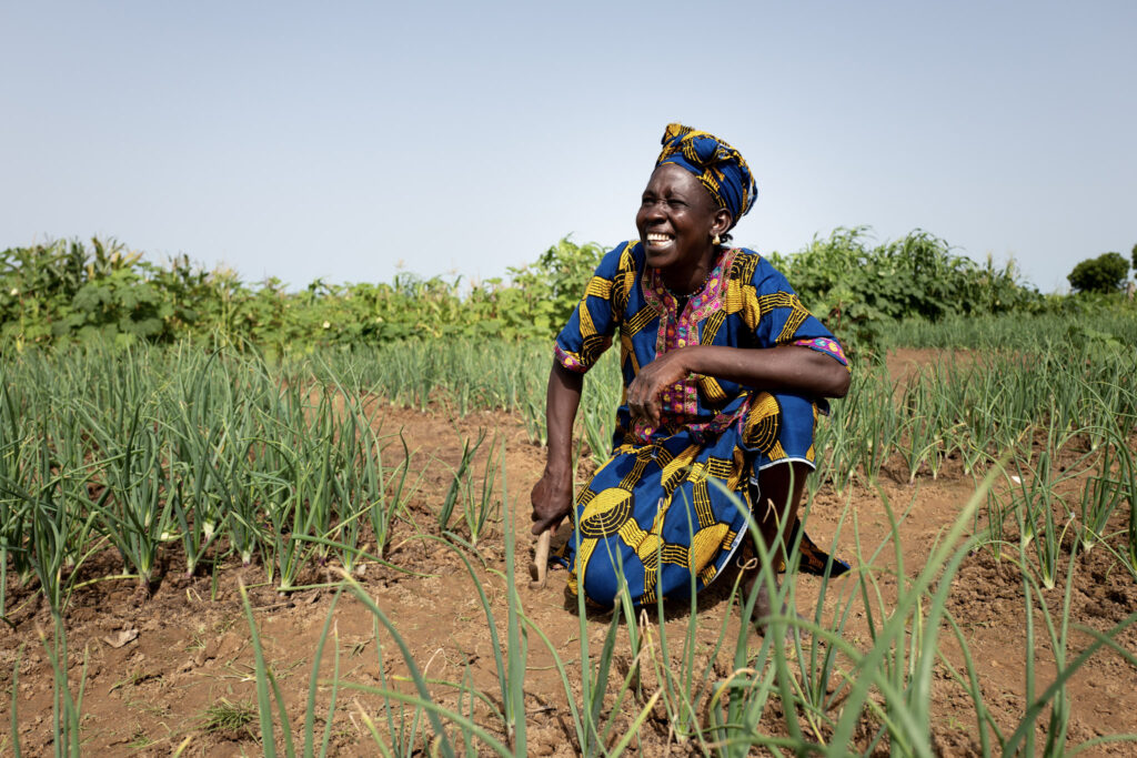 A women in a field smiling.