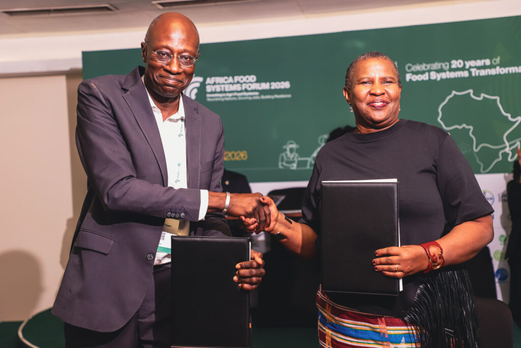 Bayella Thiam, Chief Operating Officer of IFDC (left), and Alice Ruhweza, President of AGRA (right), shake hands after signing the MoU.